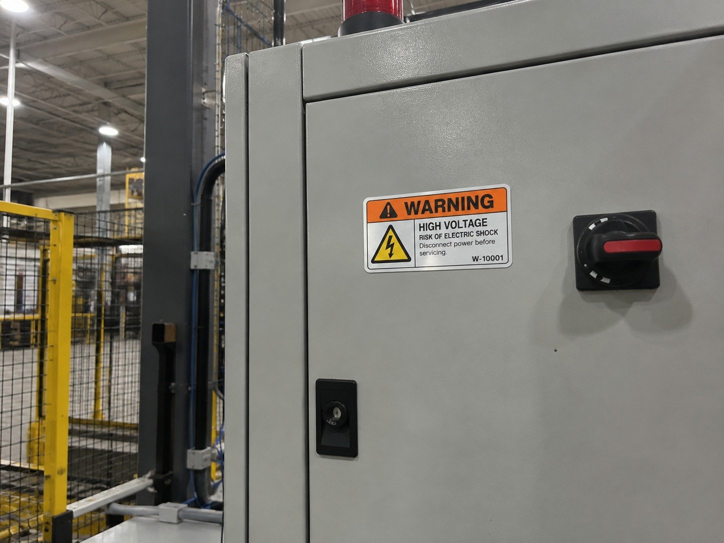 Correct warning label placement near machine guards, electrical panels, moving parts, and service access areas